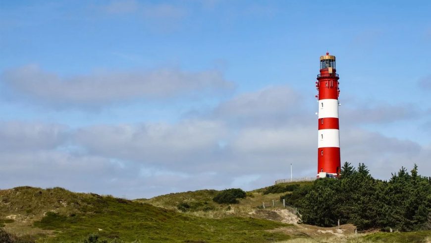 Dünengras und Leuchtturm, der Strand ist nicht weit - Radfahren auf Nordseeinseln ist einzigartig.